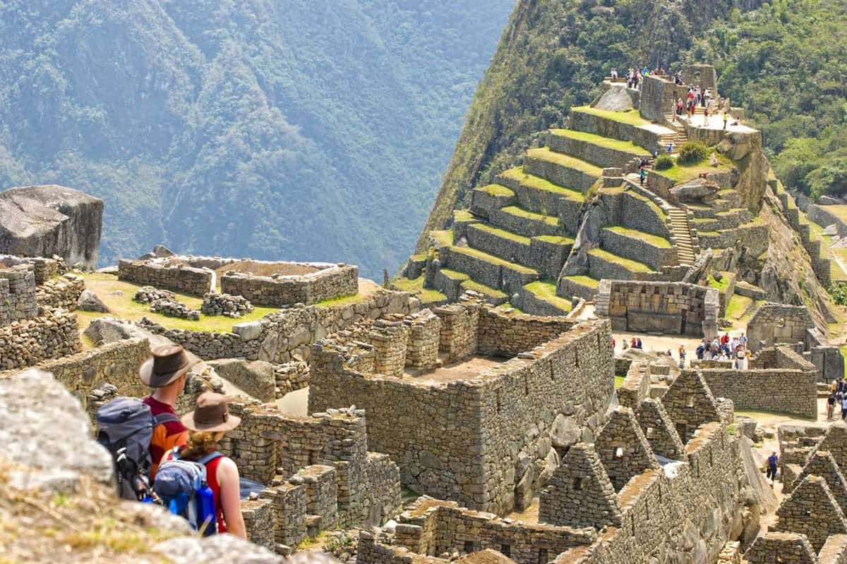 Two people sit and admire Machu Picchu ruins