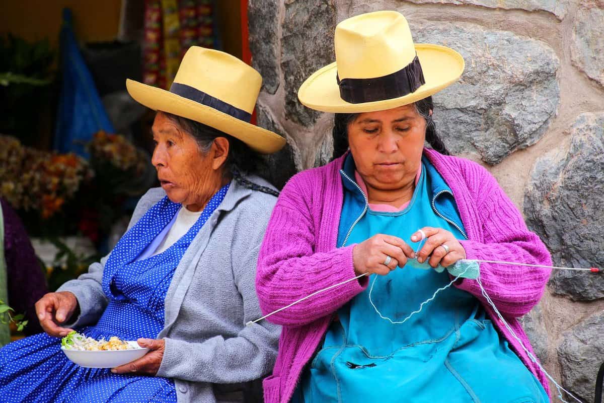 Two women sit together at a market
