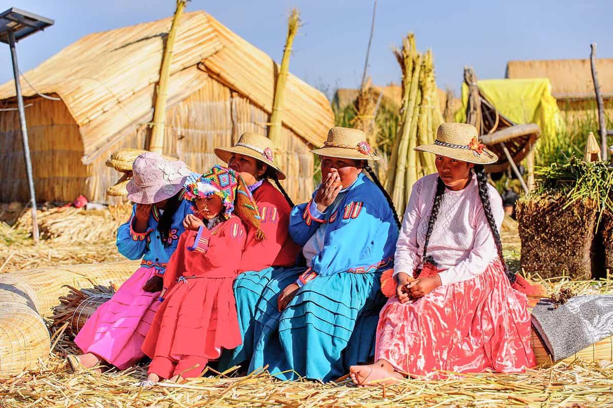 Cholitas sat together on a reed island in Lake Titicaca