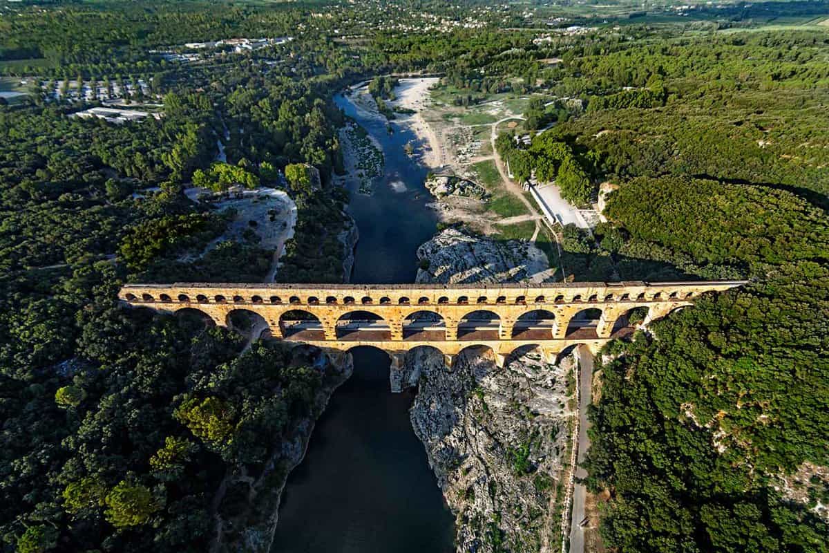 Aerial view down on the aquaduct spanning a river surrounded by forest