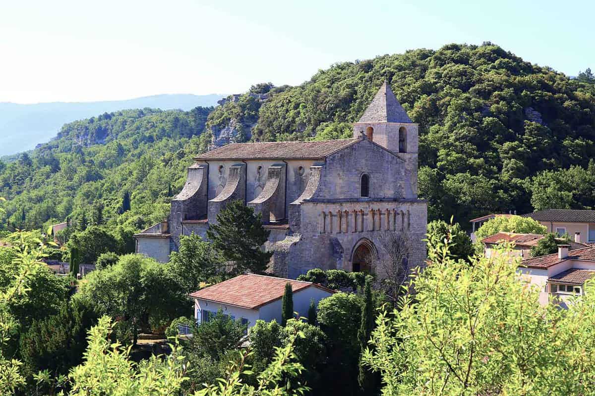 A village church surrounded by trees and hills