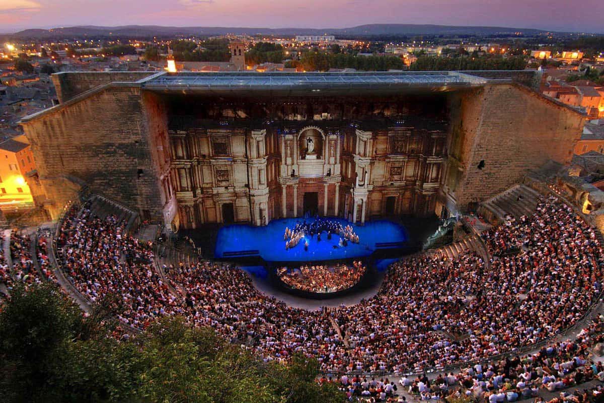 VIew of the theatre at night filled with people watching a performance