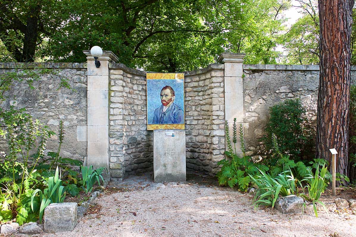 A portrait of Van Gogh set on a pillar, by a stone wall