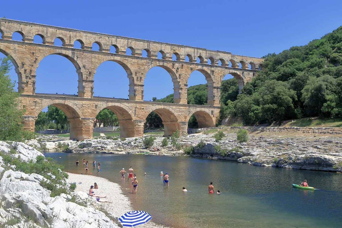 veiw of the aquaduct spanning the river, with people swimming below