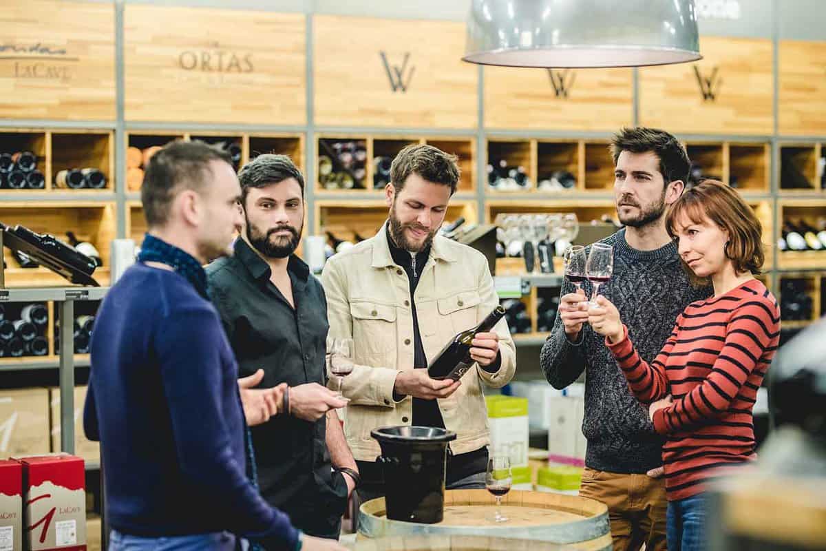 Group of people in a wine shop having a wine tasting