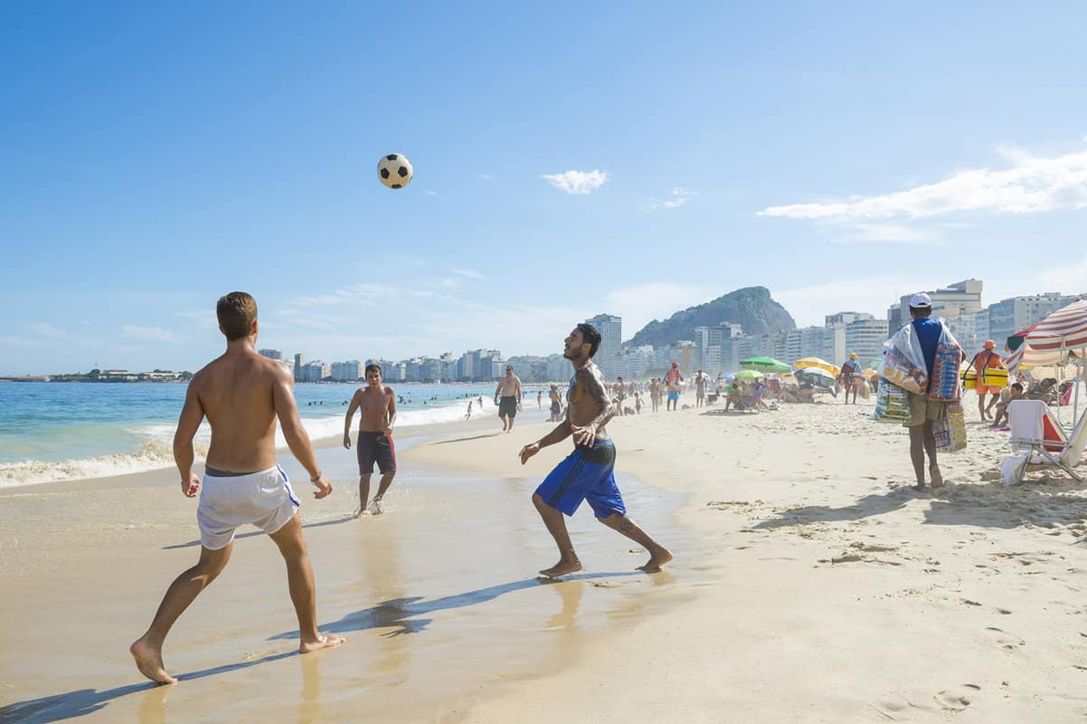 People play football sandy beach