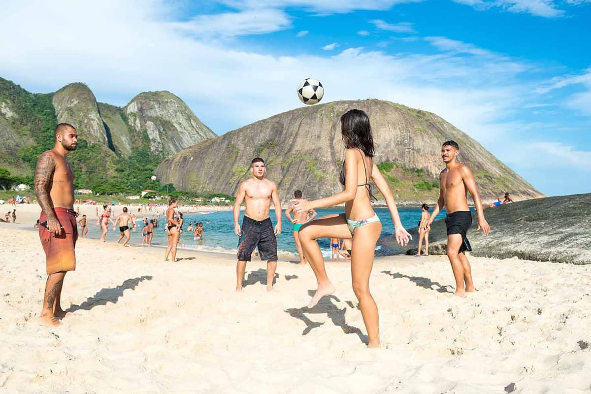 People play football on the beach