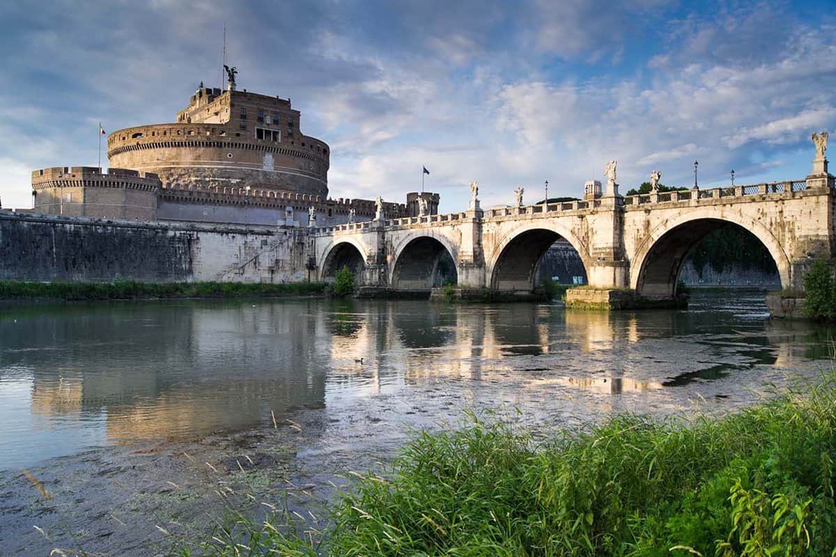 Castel Sant'Angelo and bridge Ponte Sant'Angelo over the Tiber river on sunset in Rome, Italy