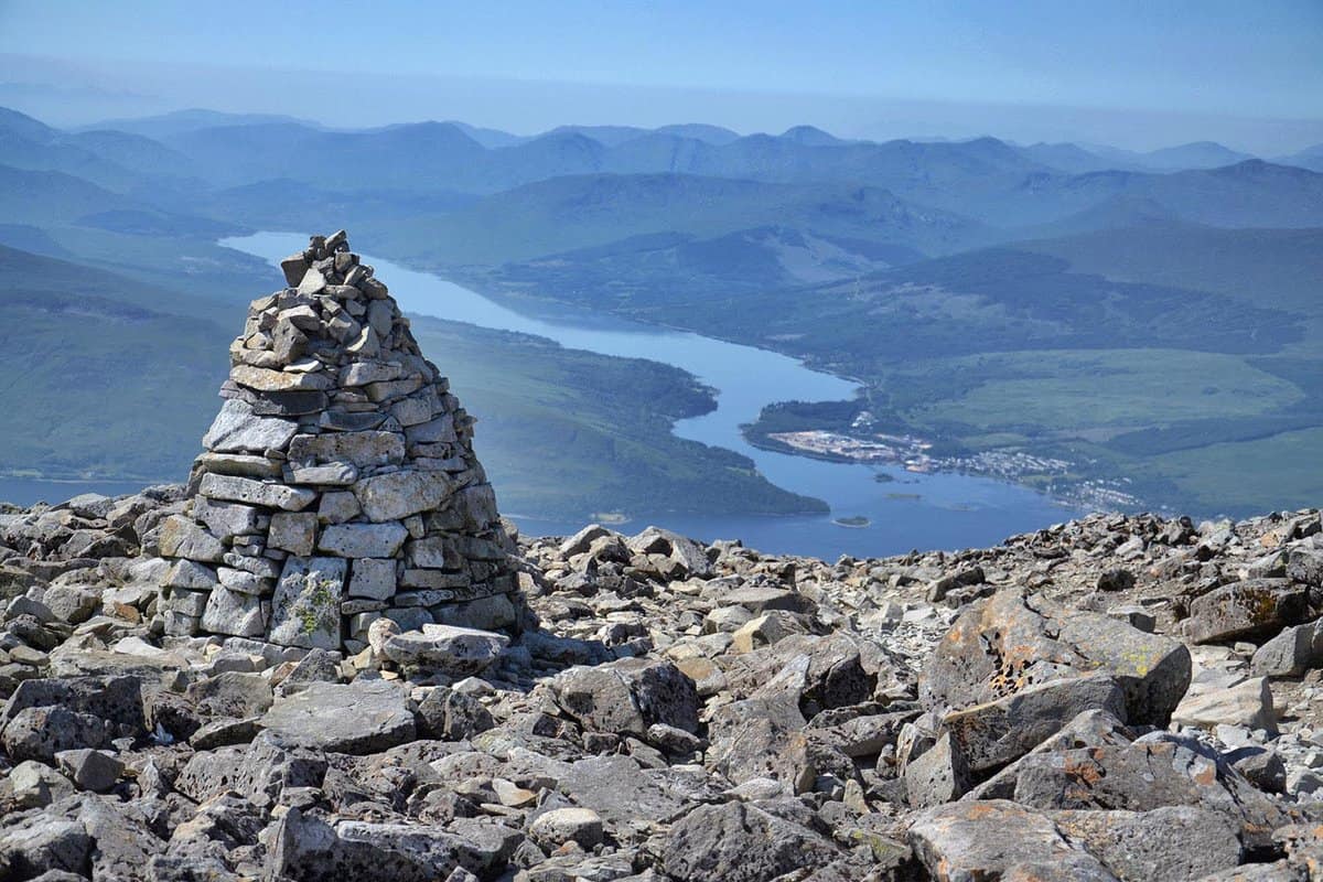 A rocky cairn at the peak, with panoramic views behind it