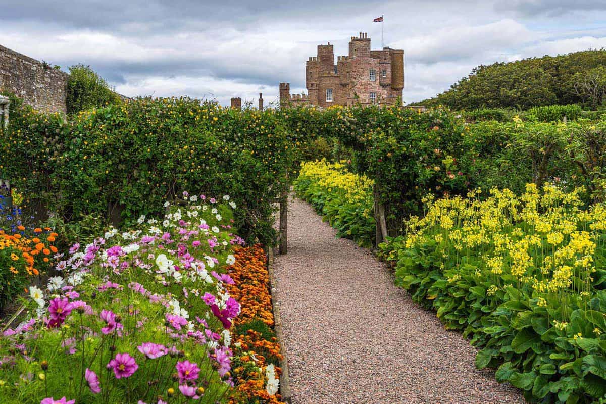 A path through beautiful gardens, with the castle just behind
