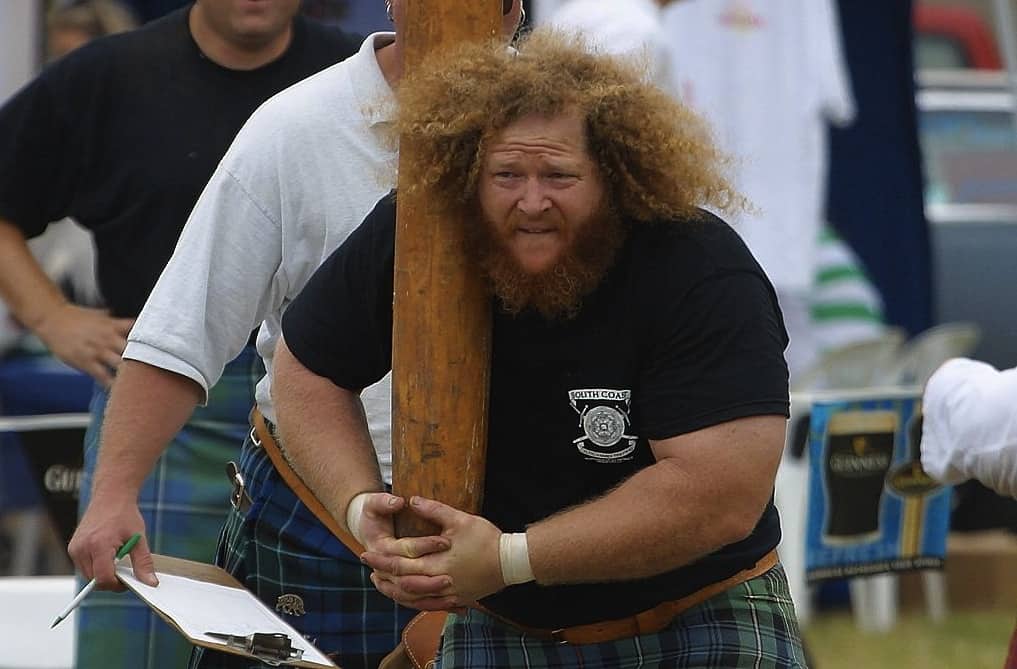 Close up of a participant in Tartan kilt holding a caber at the Highland Games