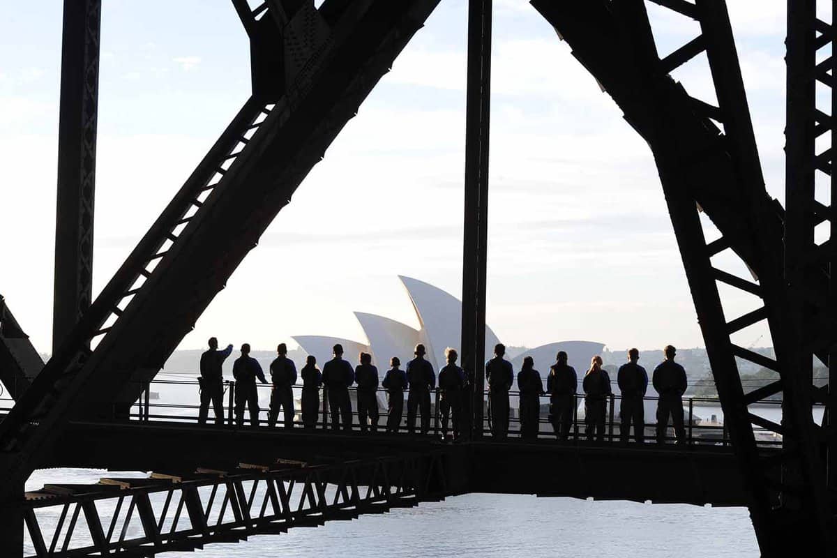 abstract of group amongst bridge girders with opera house behind