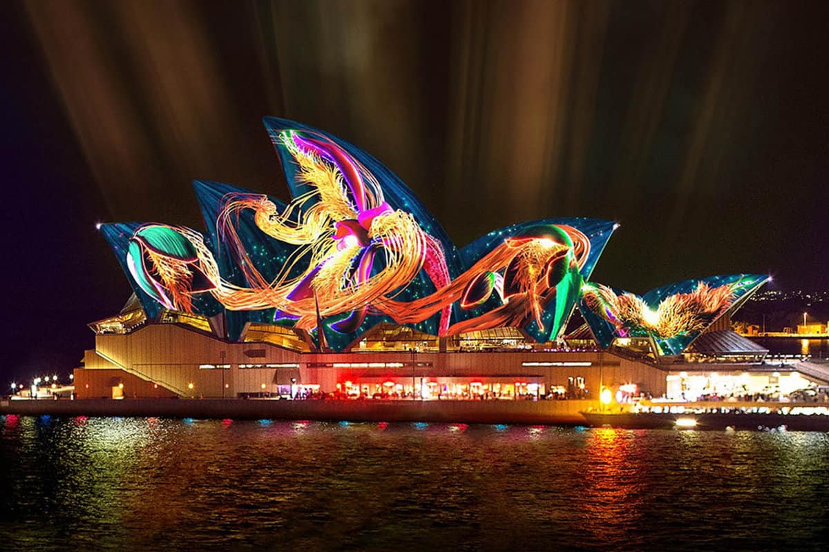 Sydney Opera house with projections on the roof at night.
