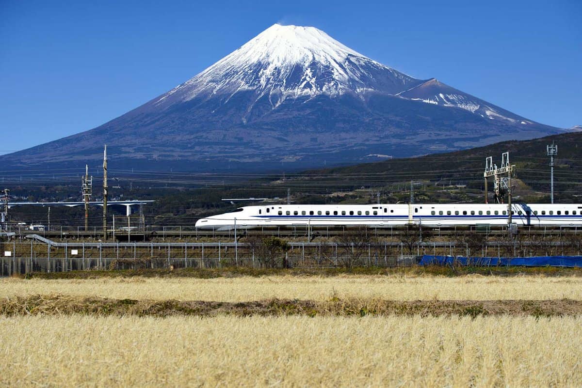Bullet train speeding in front of Mount Fuji