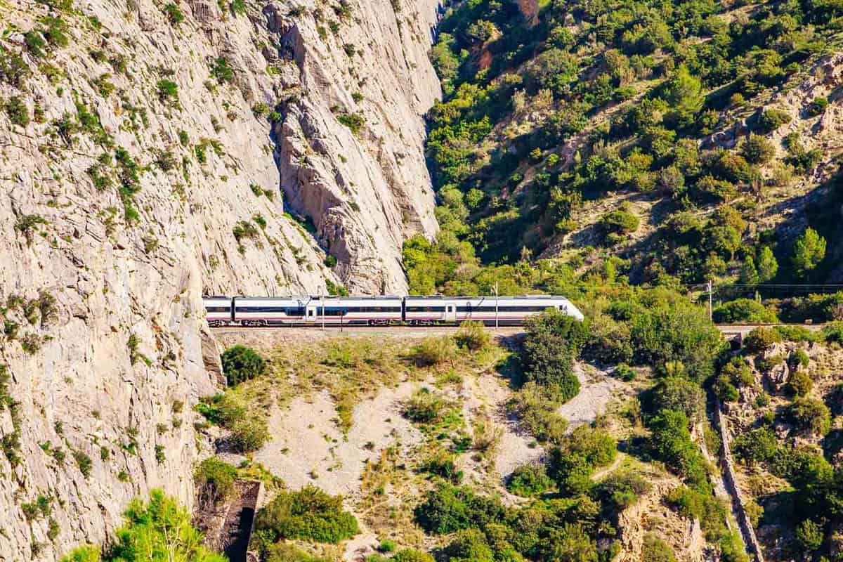 Train existing a tunnel in the mountains