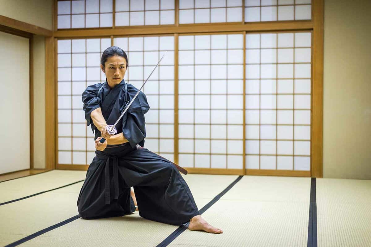 Japanese martial arts athlete training kendo in a dojo - Samurai practicing in a gym