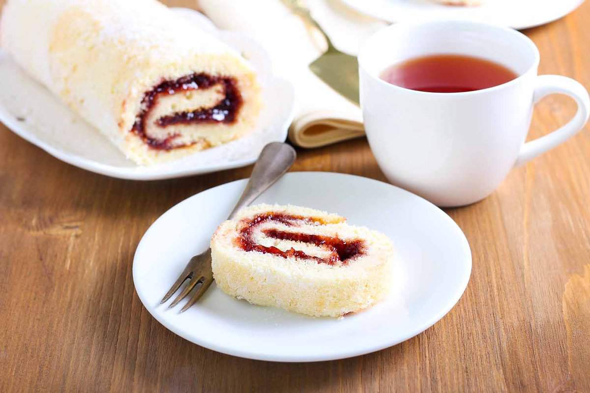 slice of jam roly-poly with cup of tea