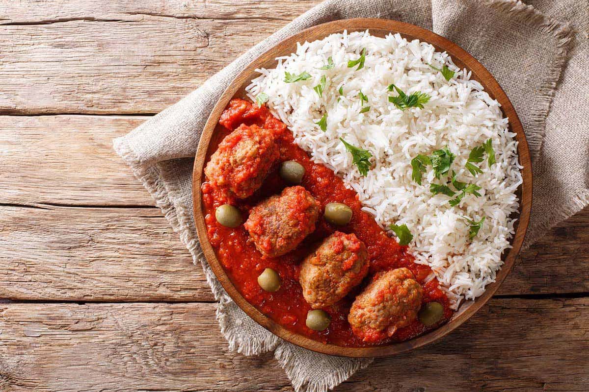 close up of a bowl of Soutzoukakia Beef,Meatballs,In,A,Spicy,Tomato,Sauce,With rice