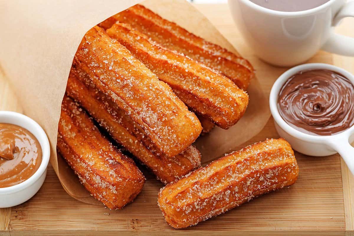 close up of Churros with sugar and chocolate sauce