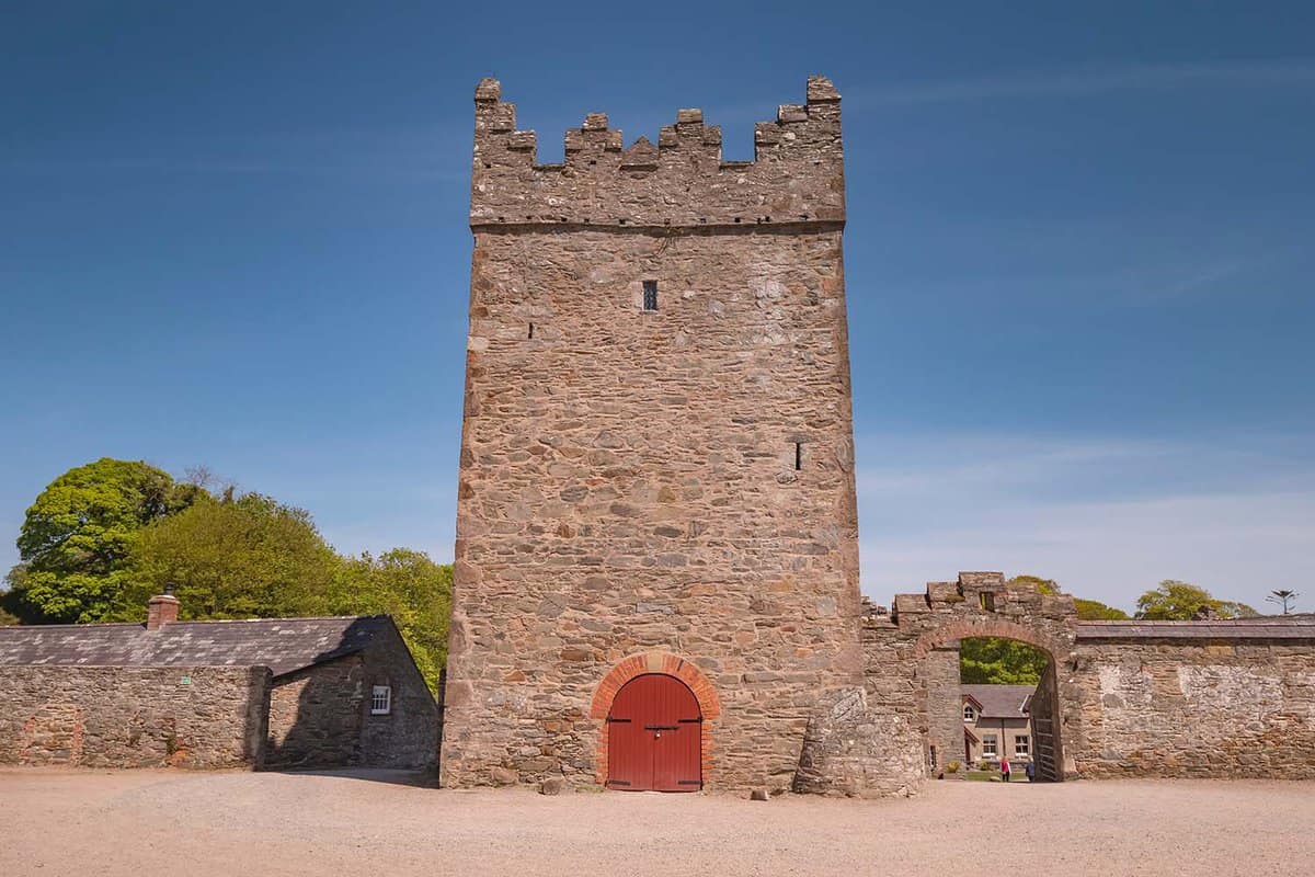 A small stone castle tower with a red door
