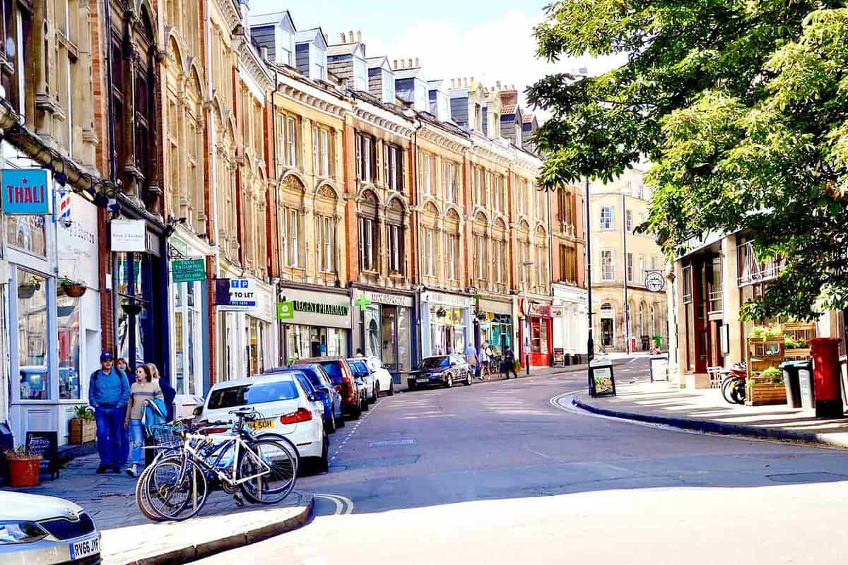 Colourful sweeping street of shops and terrace buildings in Clifton with shops underneath