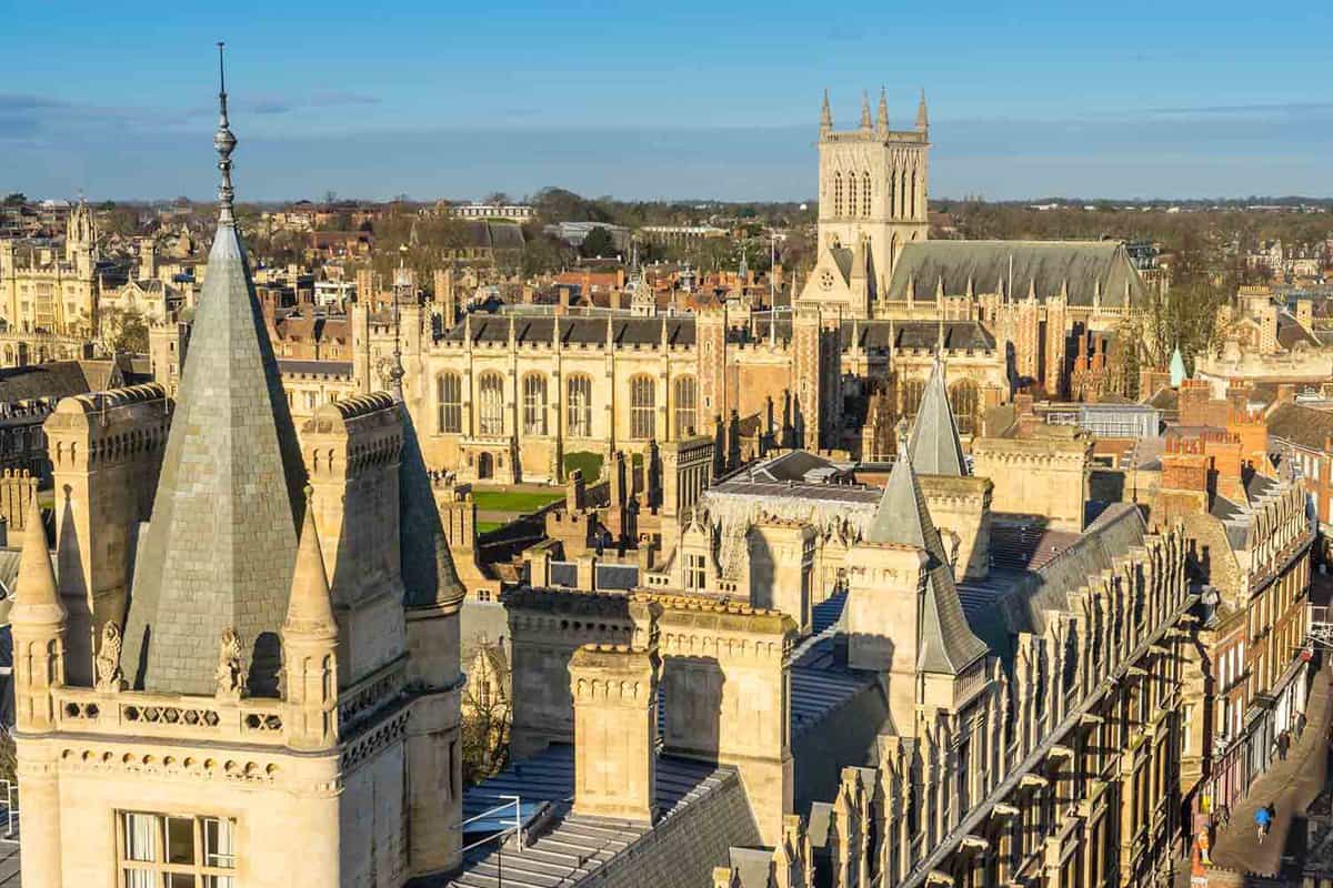 Rooftop view of Cambridge colleges including church in the background beneath blue skies