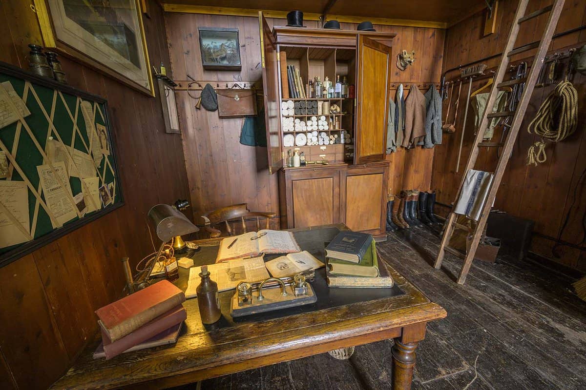 A wooden old room with lots of horse equipment around