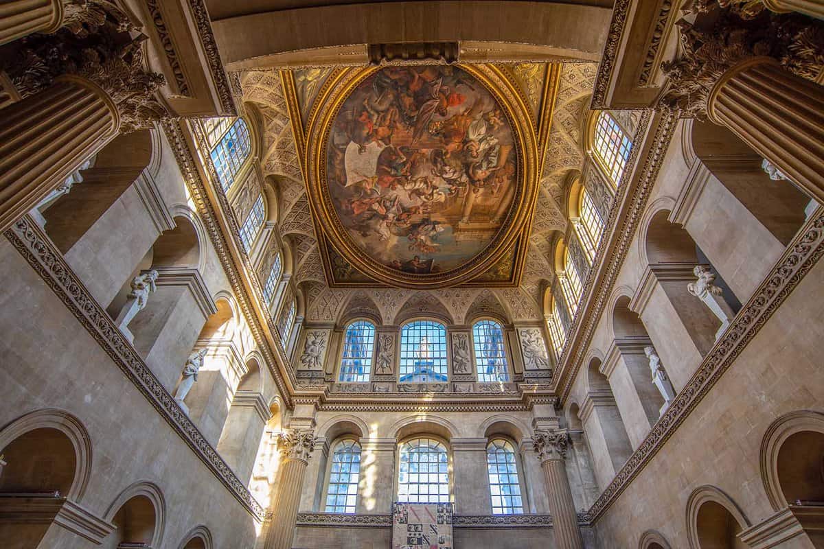 The ceiling of a hall with a painting on the ceiling and lots of windows and a giant ceiling fresco