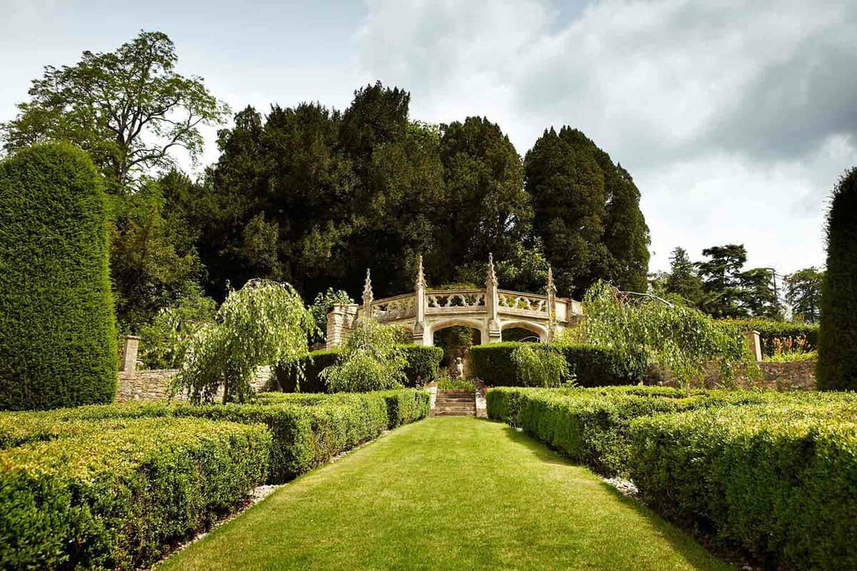 A beautiful garden leading to a manor.