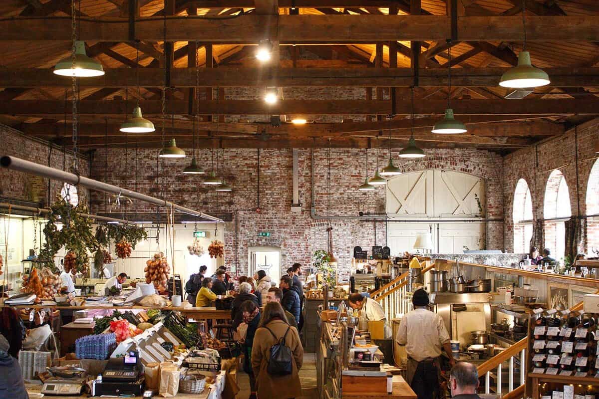 Shoppers in the large market hall of the Goods Shed with multiple stalls