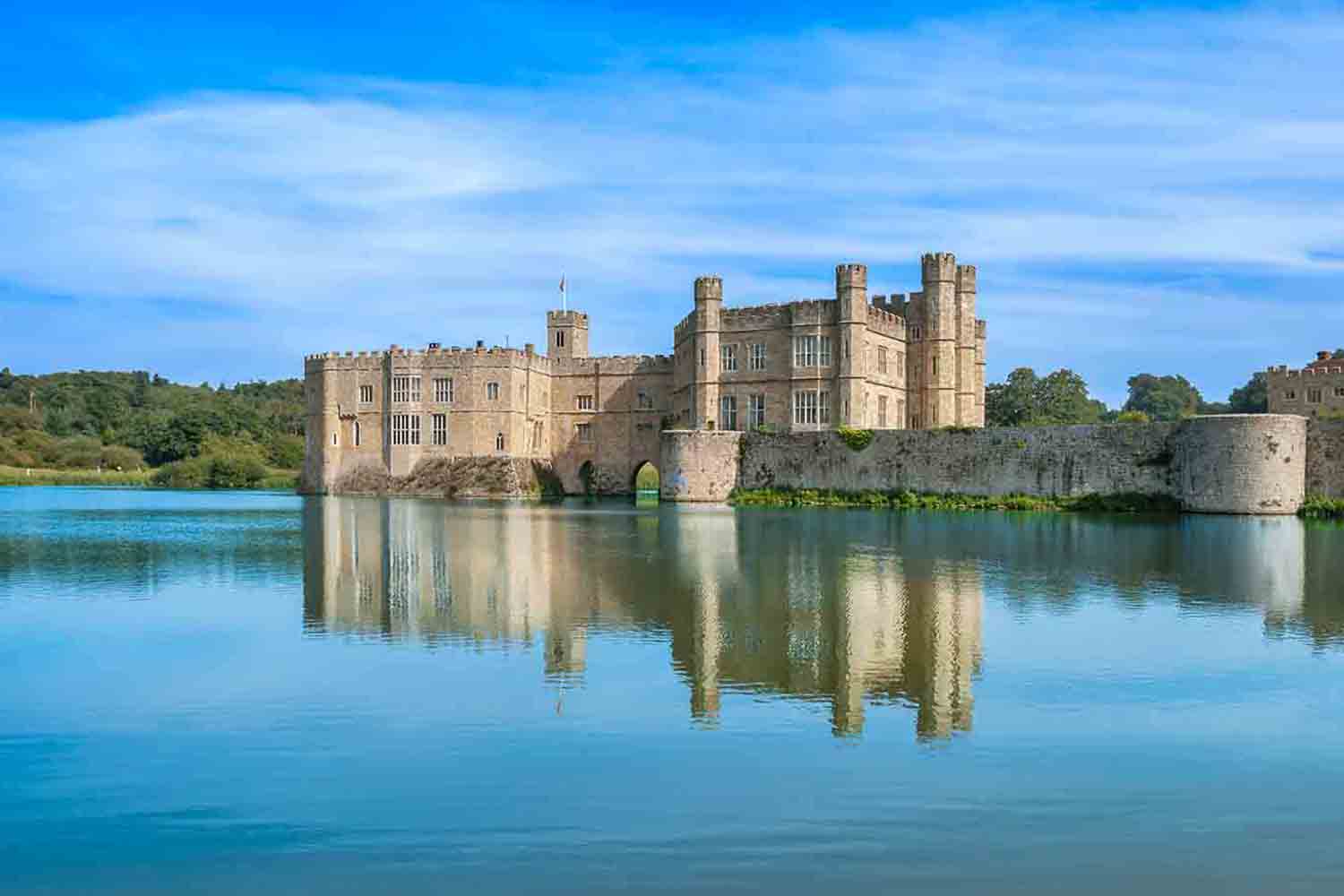 A landscape view of Leeds Castle reflecting on the lake