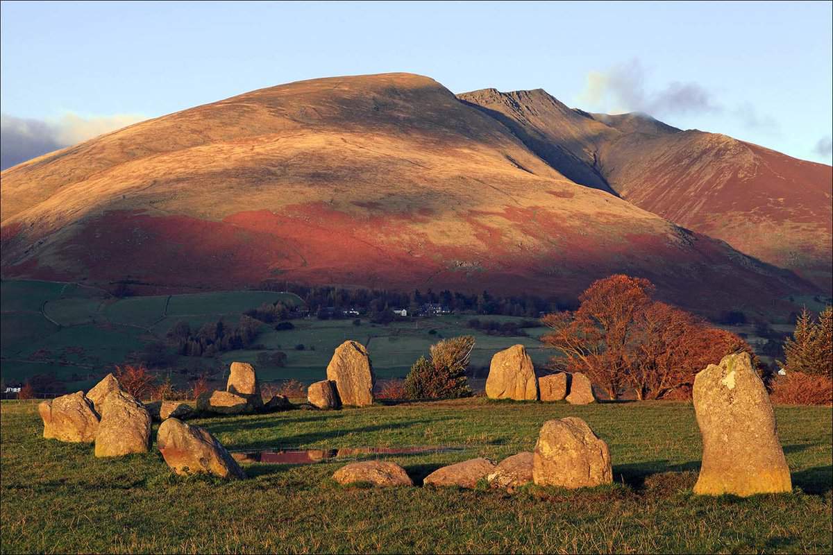 The stone circle close up in autumn, with a hill behind