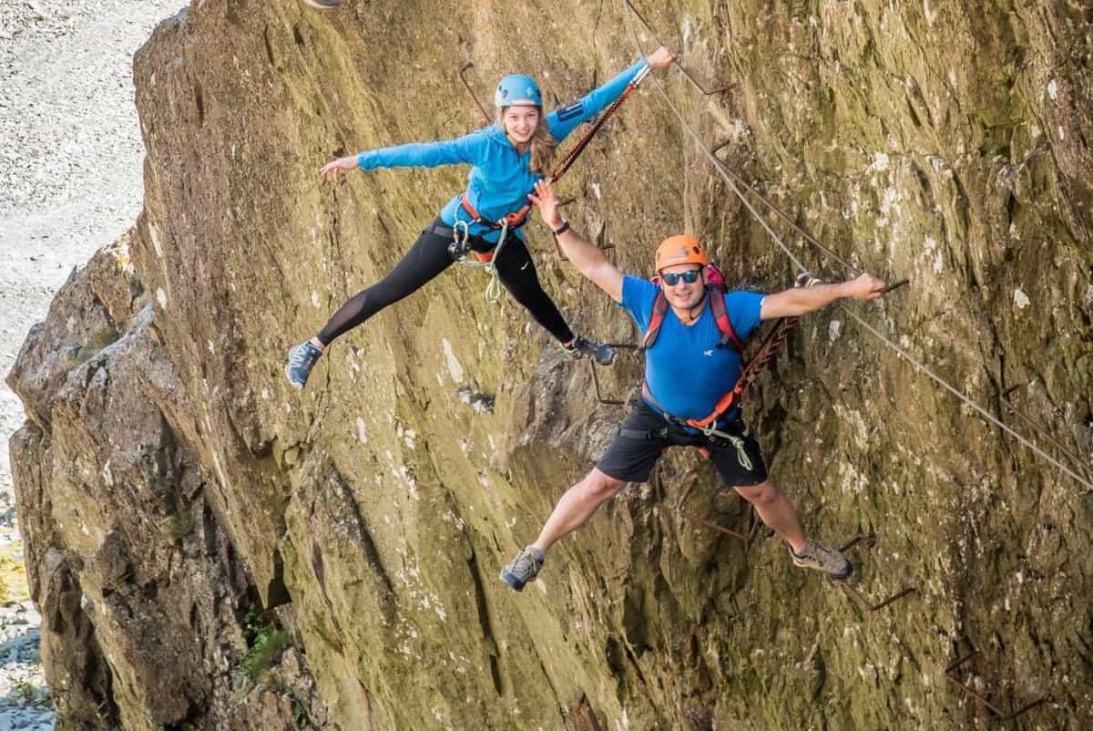 Two tourists hanging from the cliff edge
