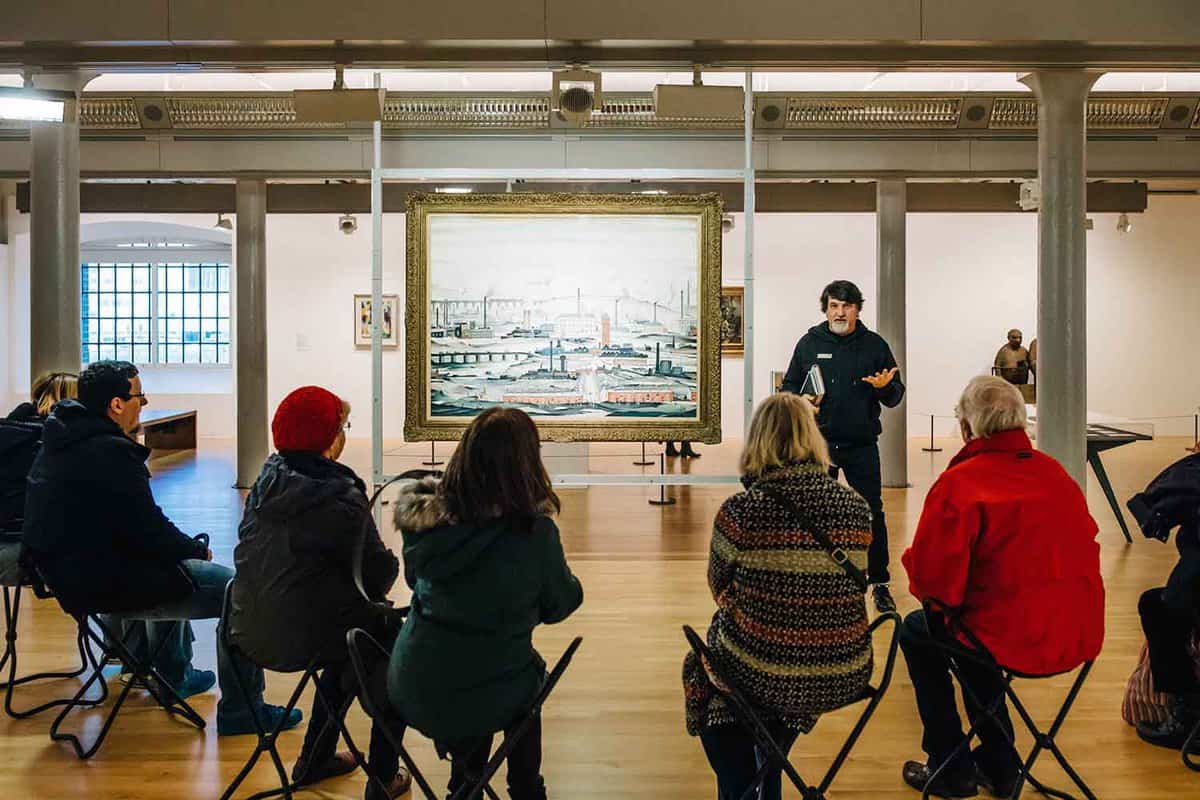artists giving a talk on a painting to a group
