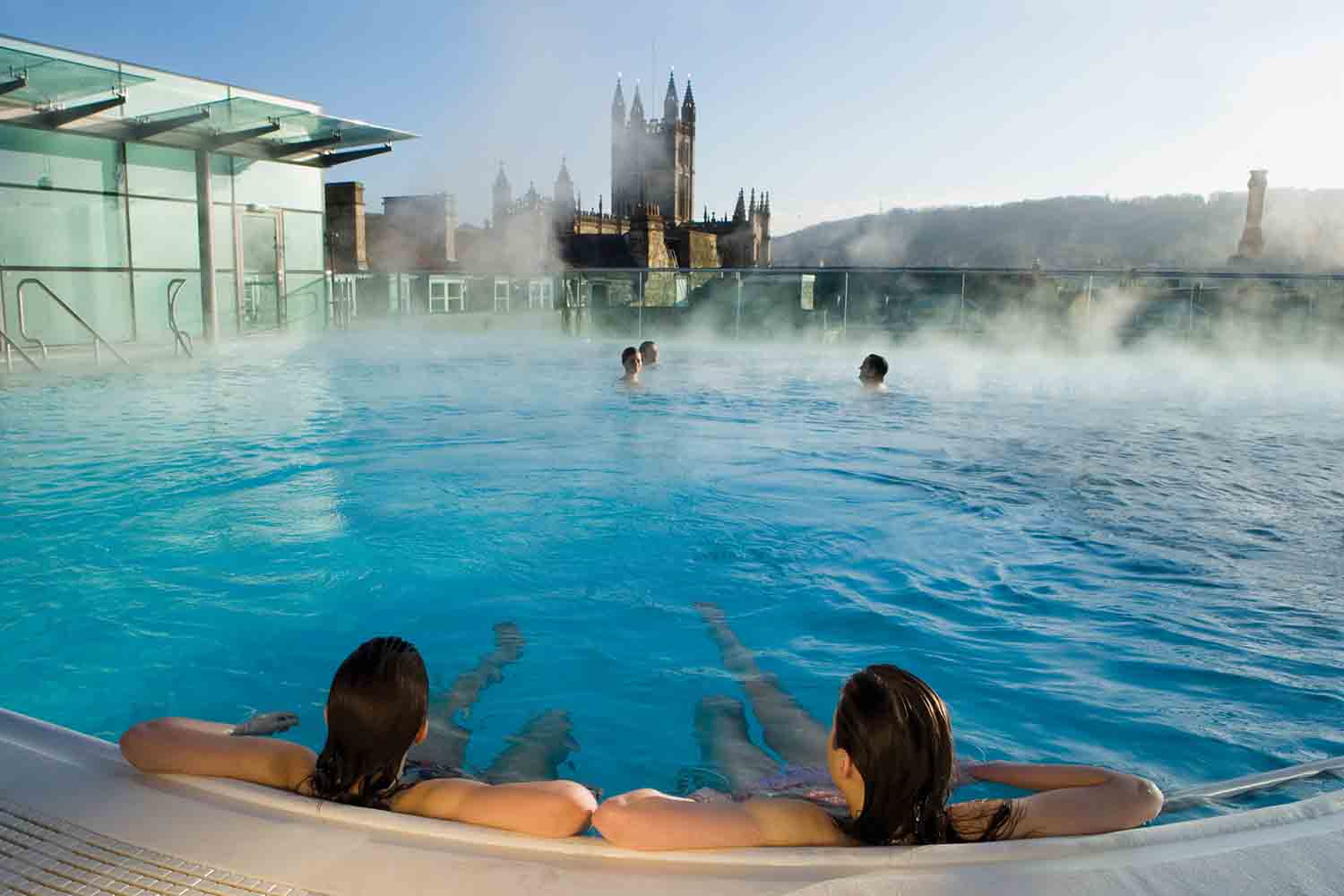Two people relax in the steaming spa waters of the rooftop spa bath