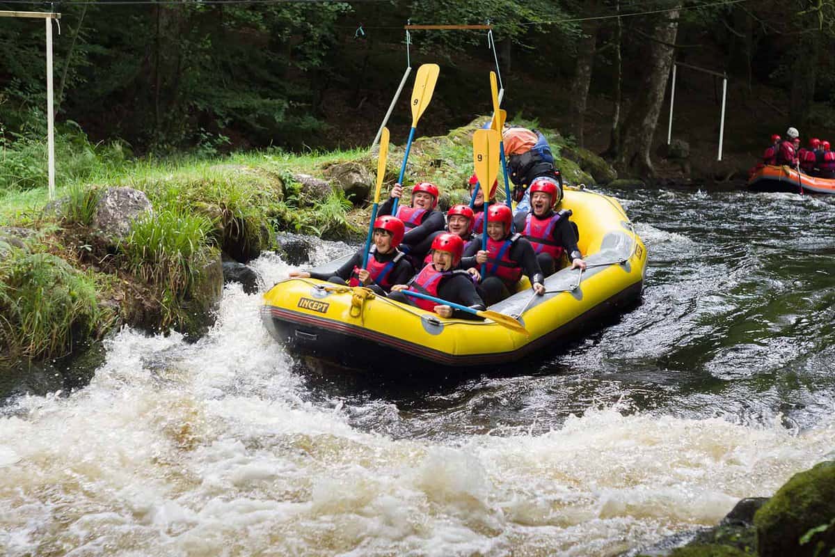 Rafters shooting the rapids at the on the River Tryweryn in the Snowdonia National Park
