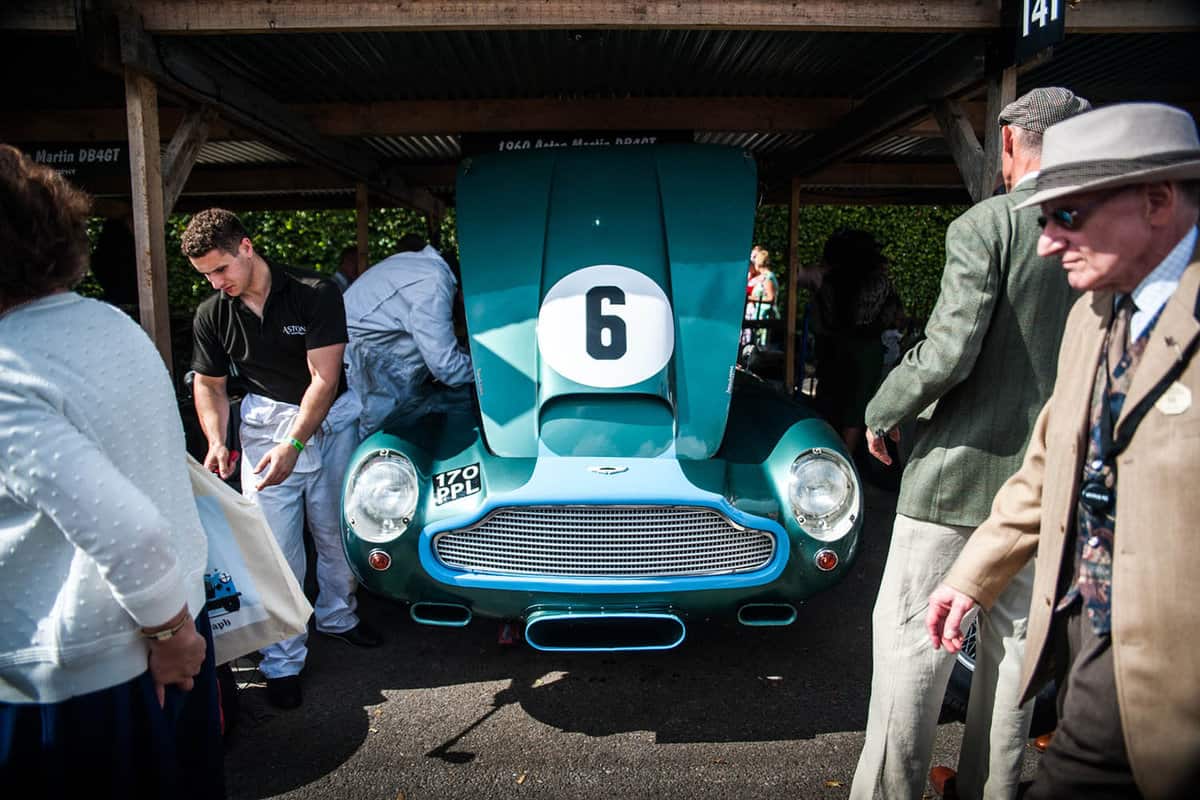 men fixing an old fashioned green car in garage