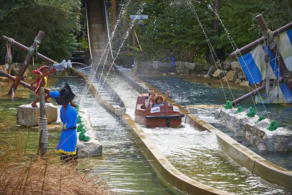 A boat going through Pirate Falls Dynamite Drench, where the water sprinklers are spraying the riders