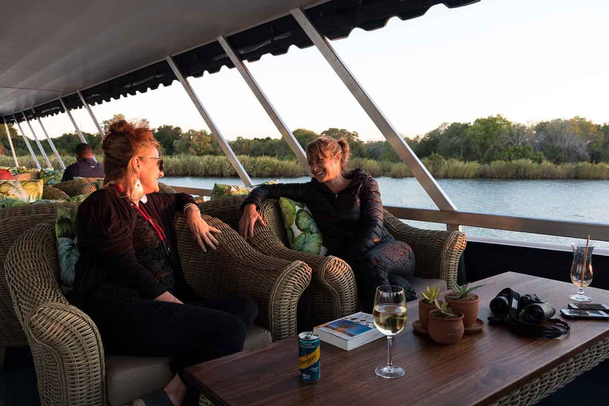 two woman enjoying a drink on the cruise boat on the Zambezi river