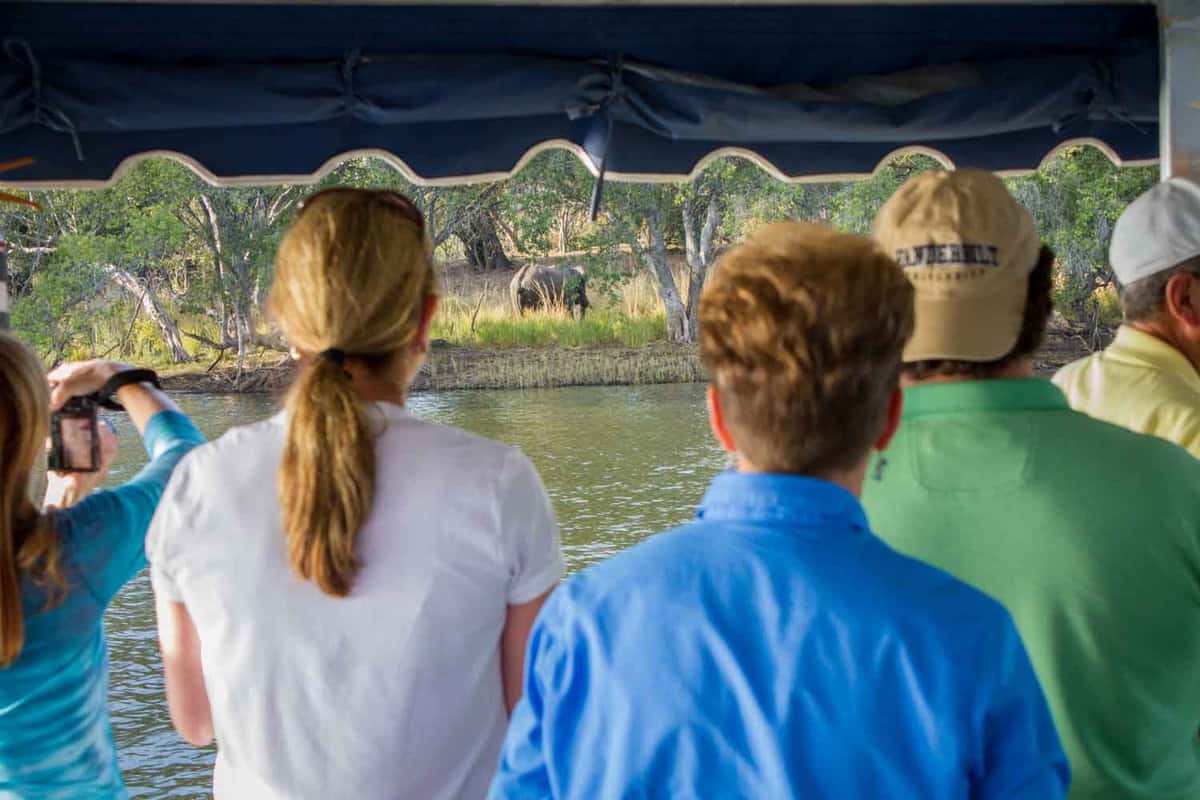 A family nature watching from their cruise boat looking out onto the Zambezi