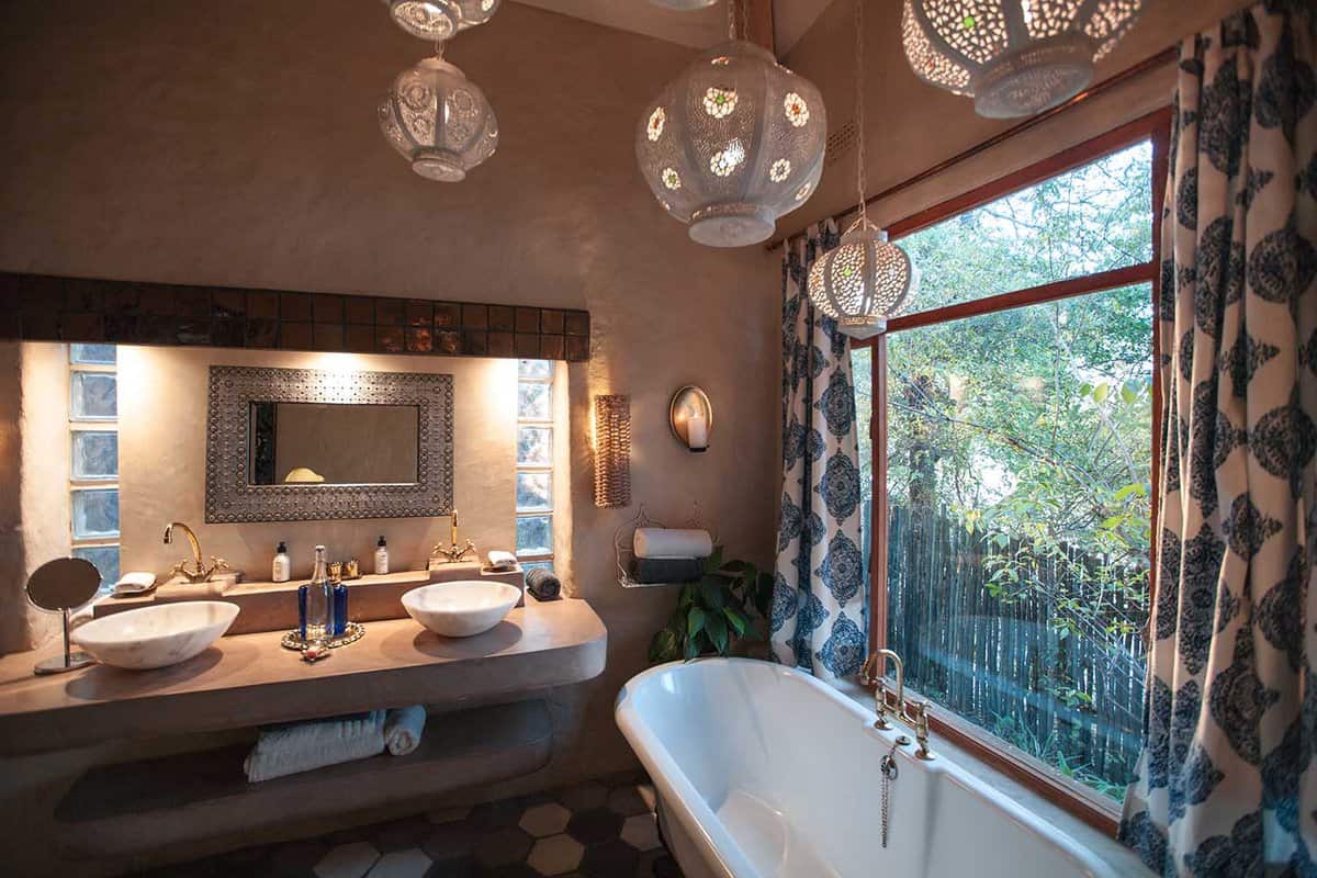 A bathroom in Tongabezi with a bath and double sink