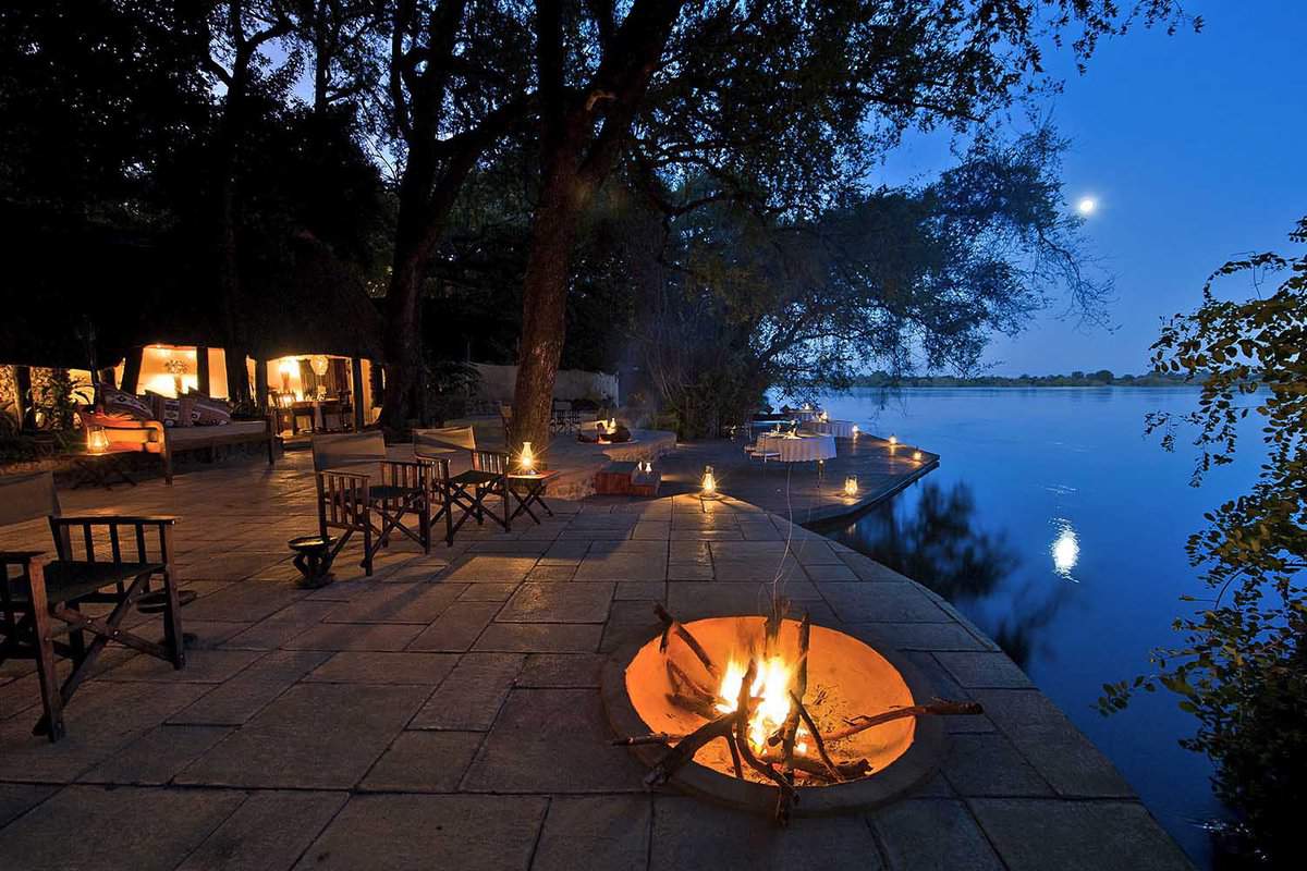 Outdoor seating with a fire bowl at dusk looking out across water