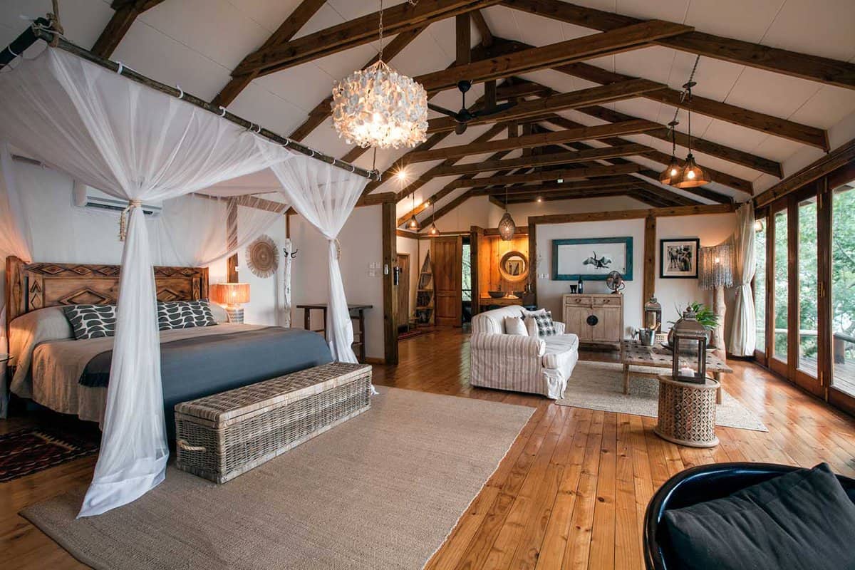 A suite at Tongabezi featuring a room with a large bed and living space