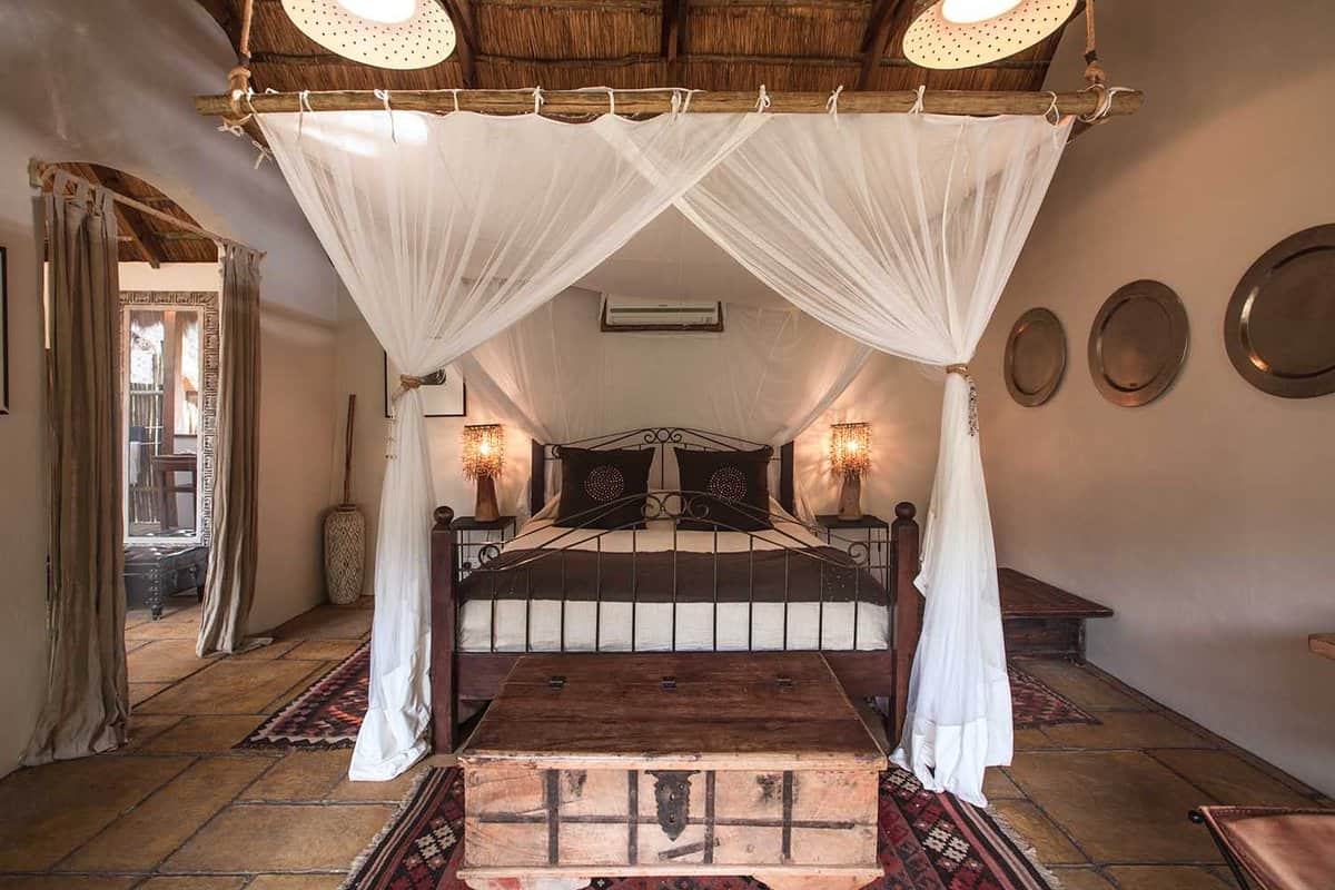 A large bed captured front on with mosquito net