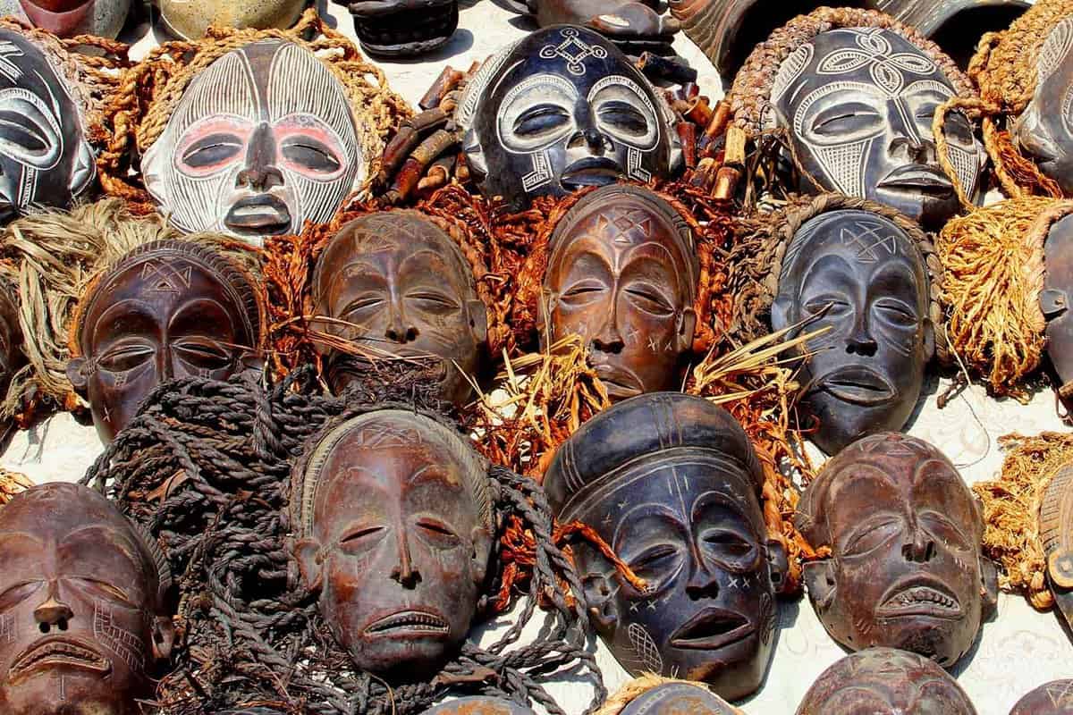 Collection traditional African wooden masks, decorative handmade crafts for sale in market store, Africa