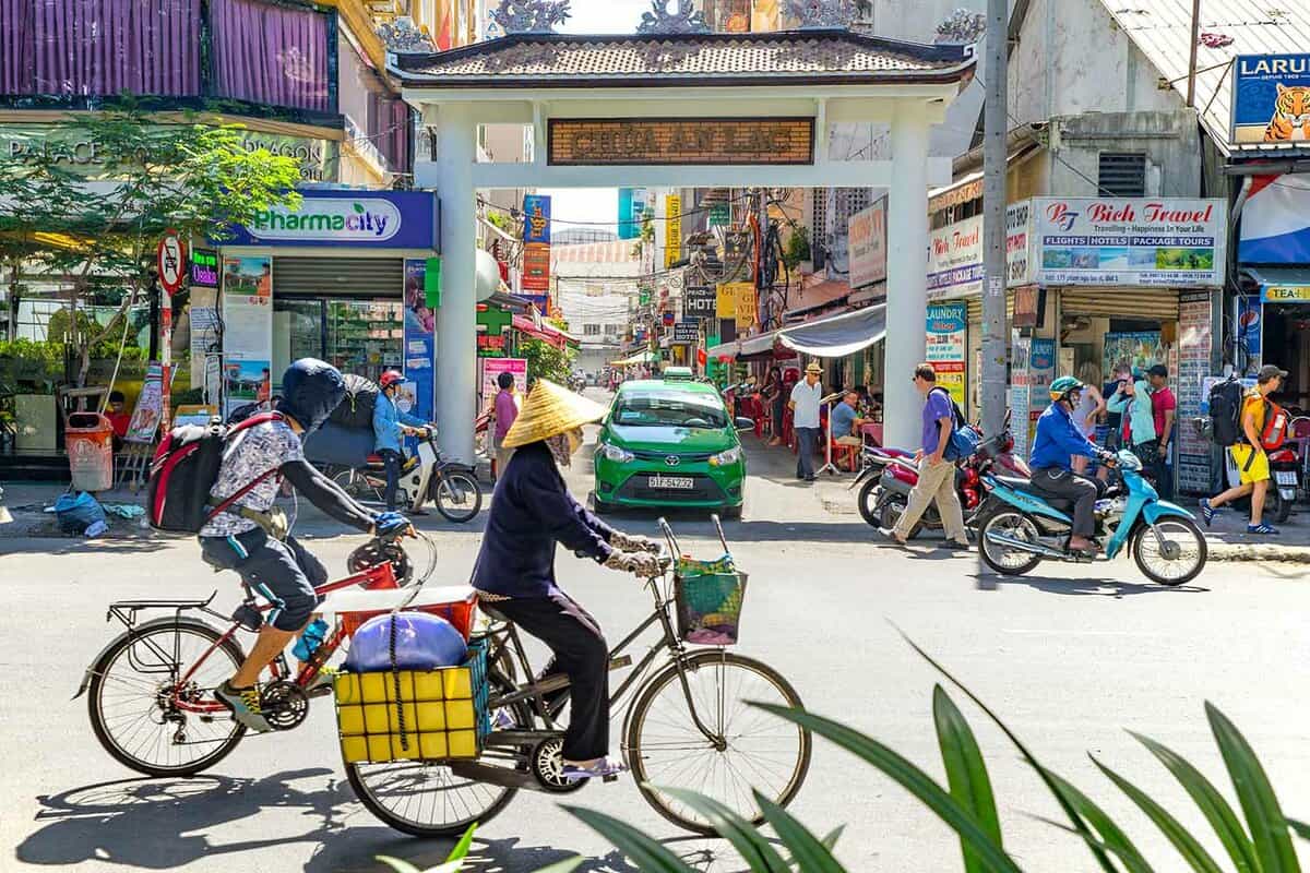 street view, woman riding a rickshaw and a shopping street behind