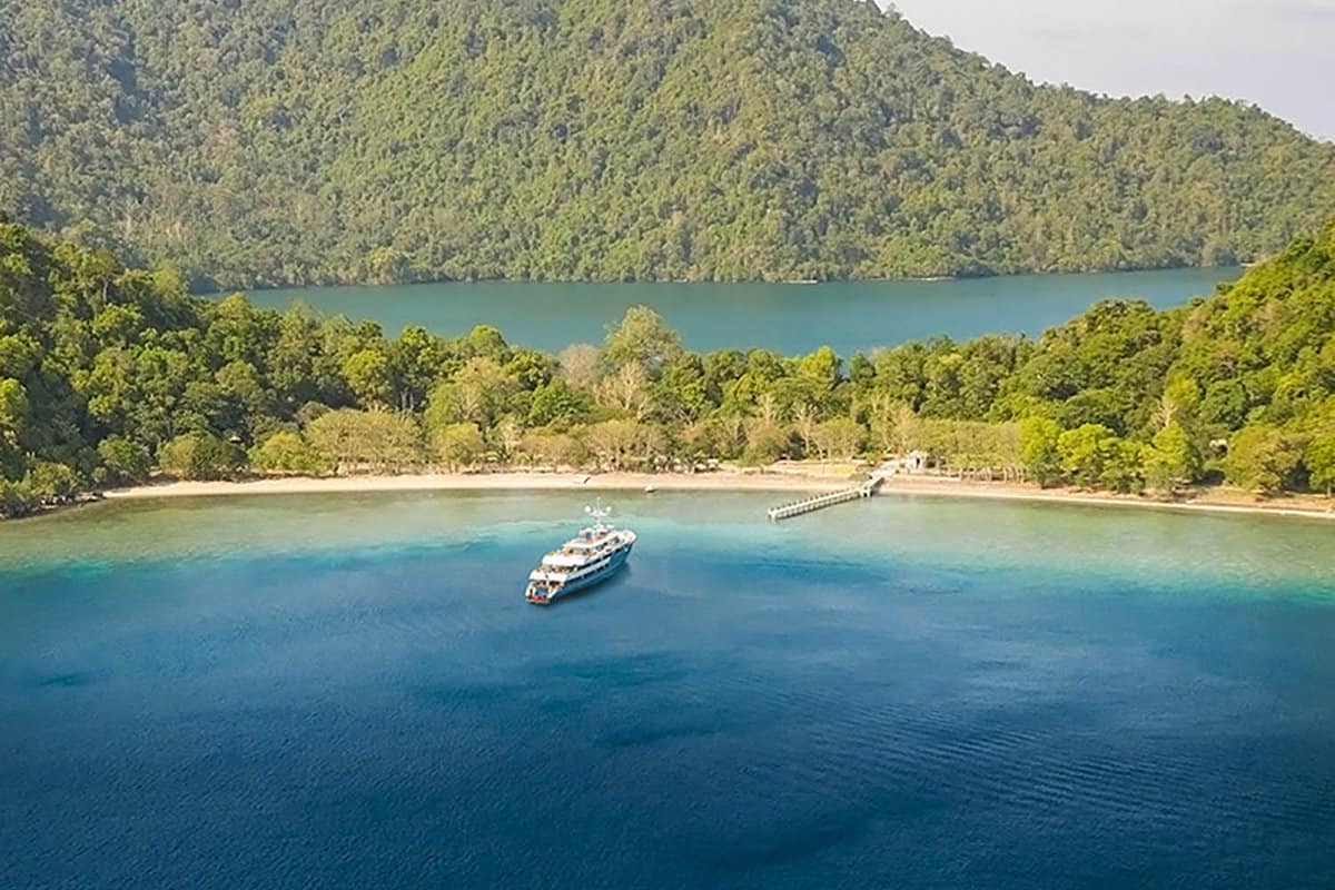 small cruise boat arriving at an island beach