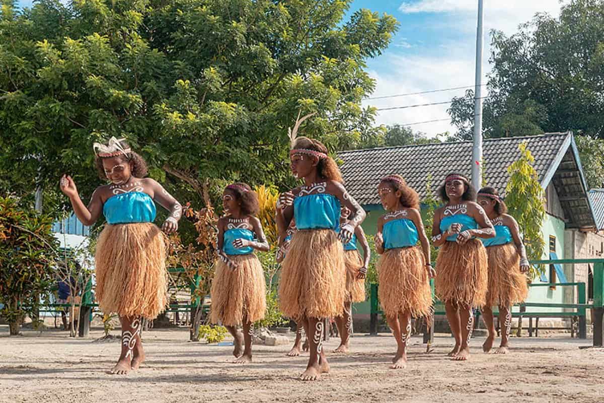 eight local women in traditional costume doing a dance