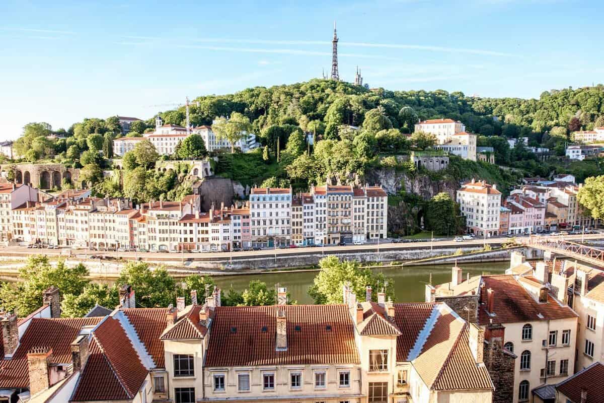 Morning aerial cityscape view with beautiful old buildings and metallic tower on the mountain in Lyon city in France