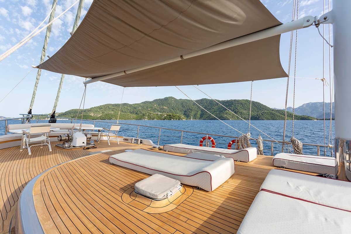 Deck of a gulet with luxury white sunbed cushions